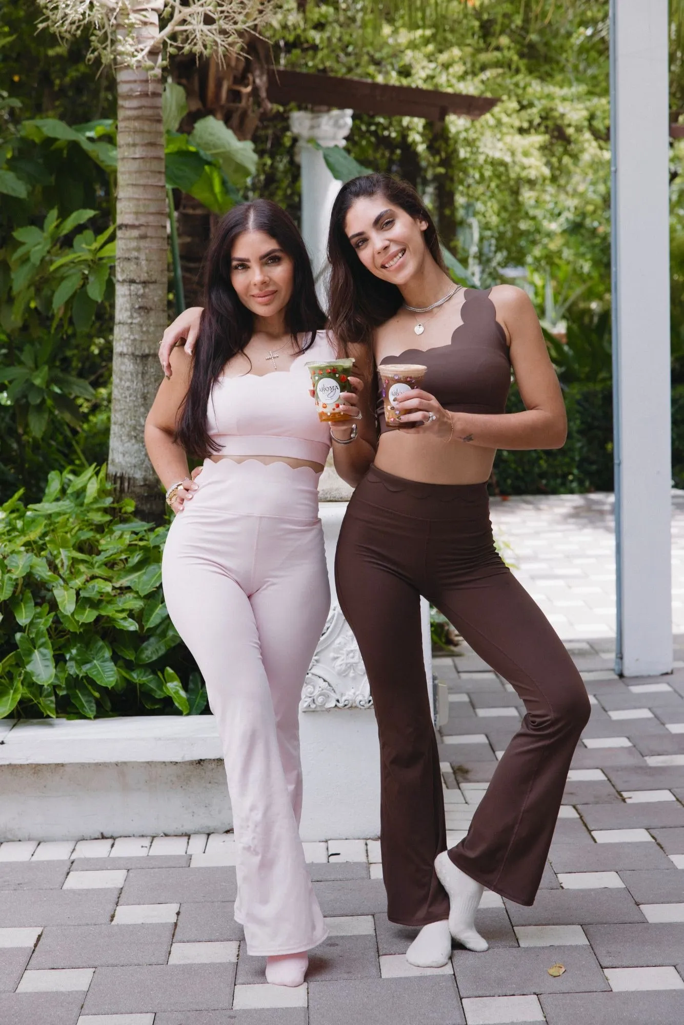 Two women in Dermabless activewear sets in a garden.